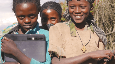 three young ethiopian girls, one is holding an ipad