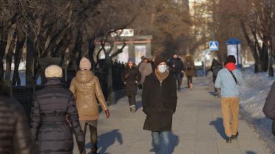 A street in a European city, people can be seen wearing face masks.