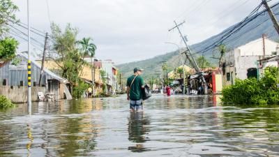 Man stood in middle of severely flood road in the Philippines 
