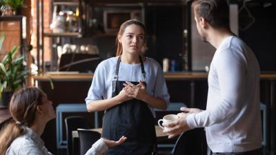 A man and woman having a heated discussion with a server in a dining place.