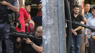 Latin American police crouched down holding guns in public place