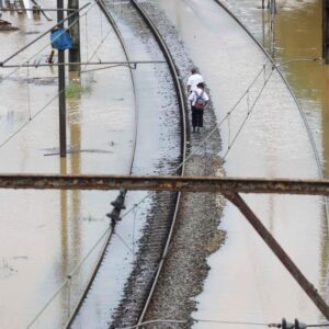 Passengers walk by train tracks submerged in water after heavy rains hit Sao Paulo, Brazil.